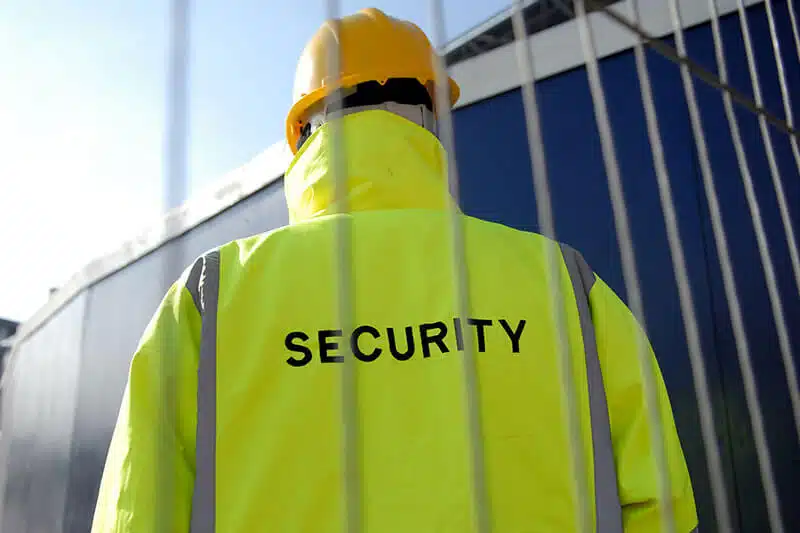 Sicherheitsmitarbeiter in gelber Weste und Helm.