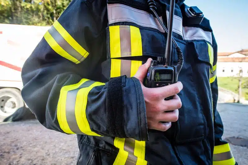 Feuerwehrmann mit Funkgerät in Uniform.