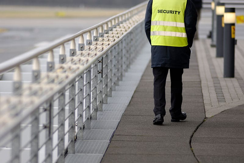 Sicherheitsmitarbeiter am Flughafen geht entlang der Plattform.