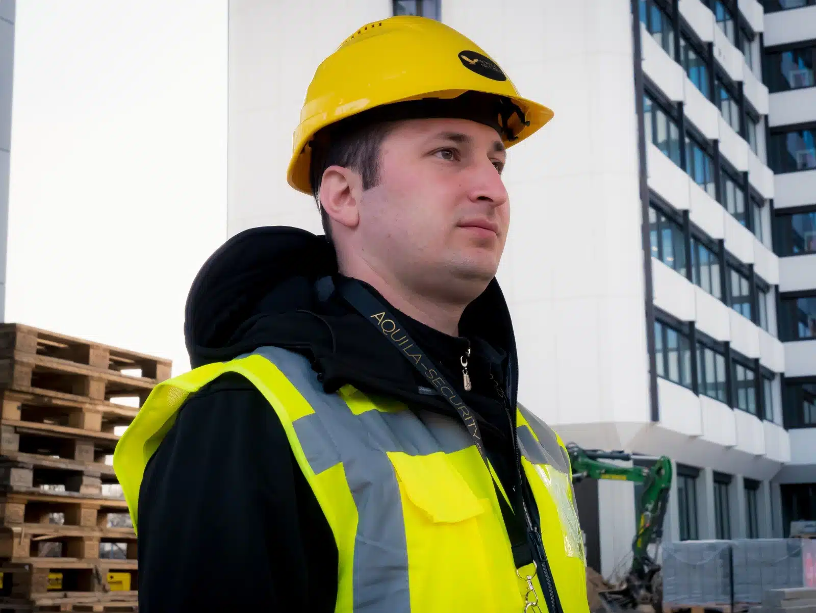 Bauarbeiter mit Helm vor Gebäude